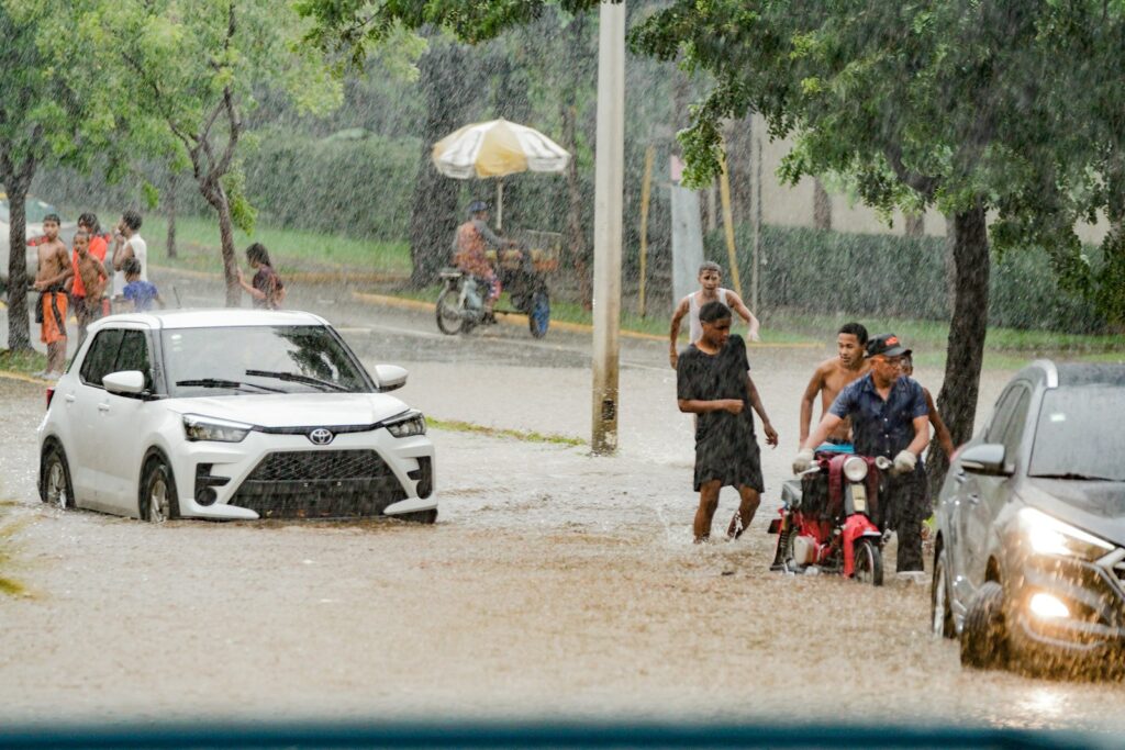 A group of people standing in a flooded street
